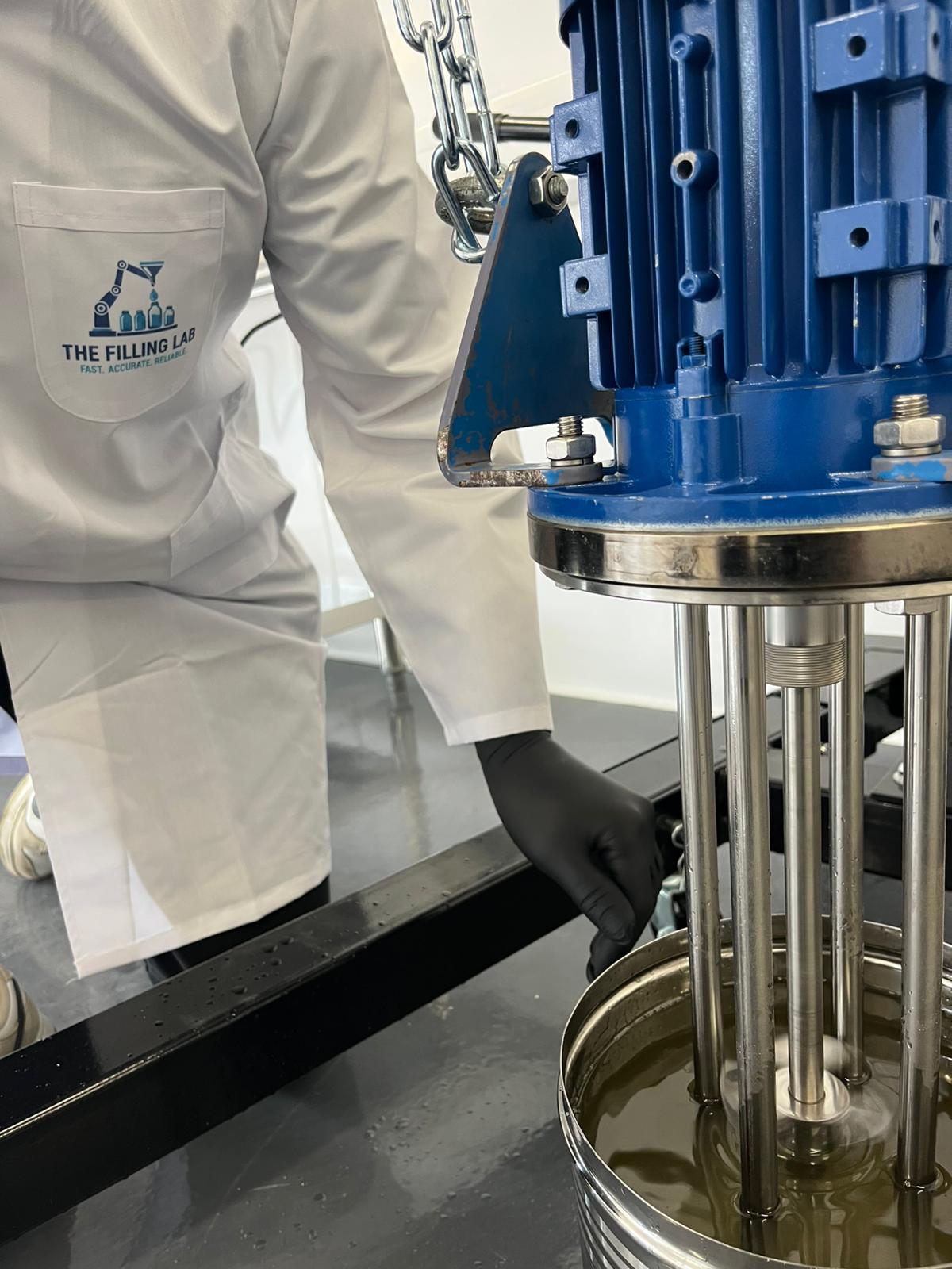 Operator in branded lab coat running high-shear mixing on plant kit.