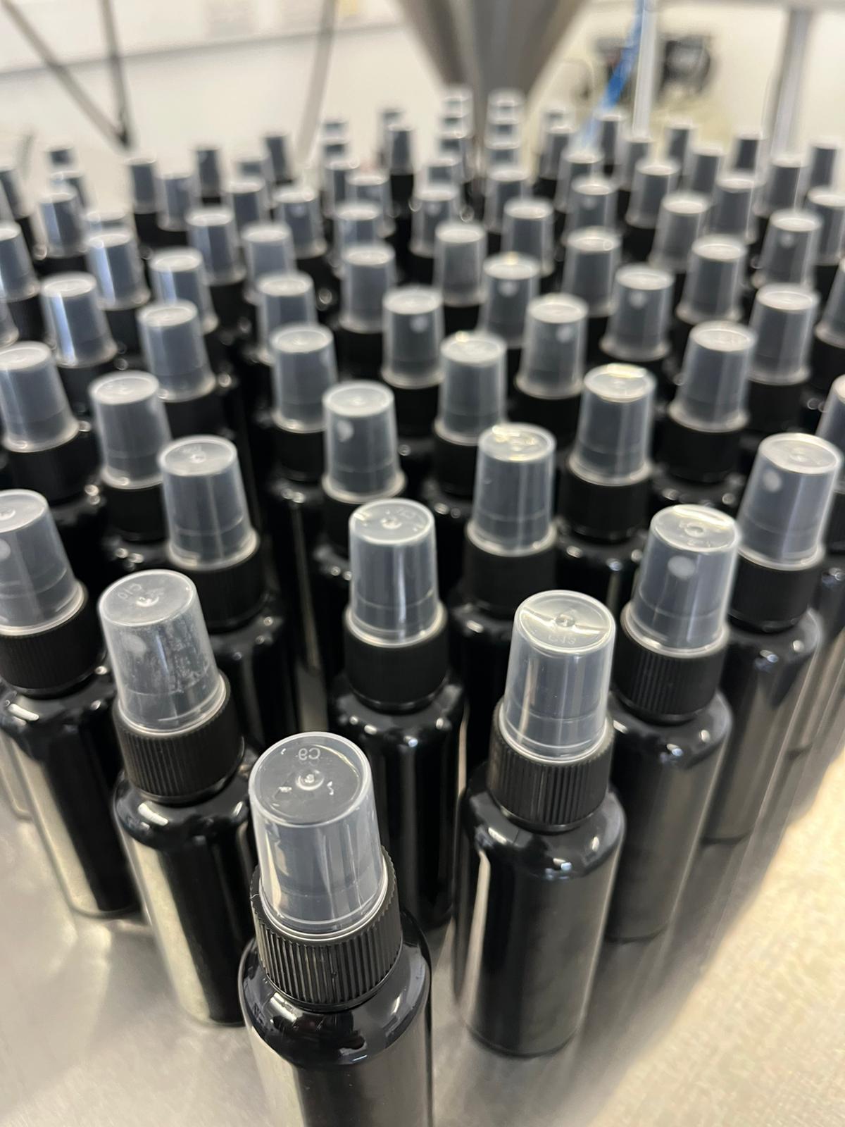 Finished spray bottles staged after filling - Fragrance and personal care.